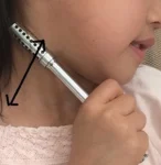 セルフケア用の小さな温熱サーミーローラーを顔に使用している当時の写真